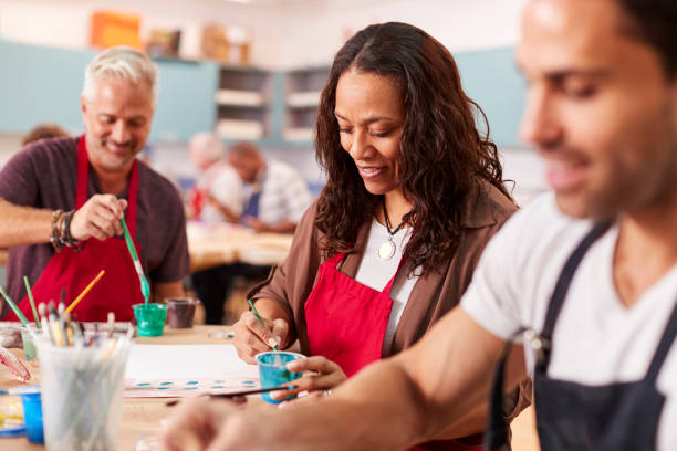 Group Of Mature Adults Attending Art Class In Community Centre