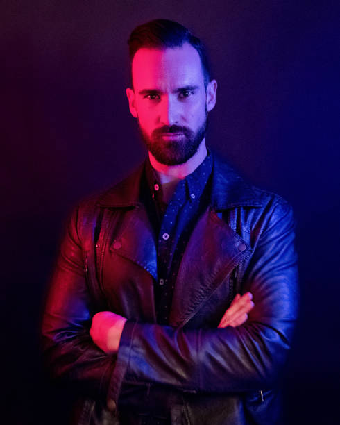 istock Handsome man wearing a leather jacket with blue and red gel lighting 1145048287