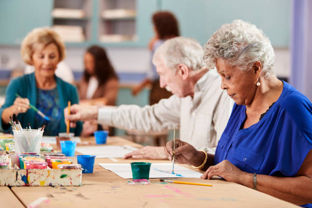 grupo de idosos aposentados que frequentam a classe de arte no centro comunitário com professor - desenhar atividade - fotografias e filmes do acervo