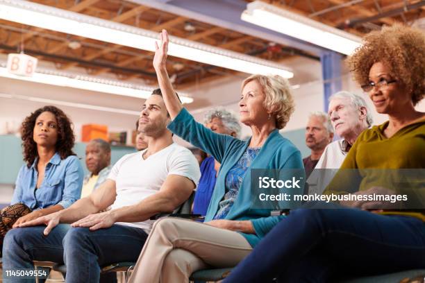 Woman Asking Question At Neighborhood Meeting In Community Center Stock Photo - Download Image Now