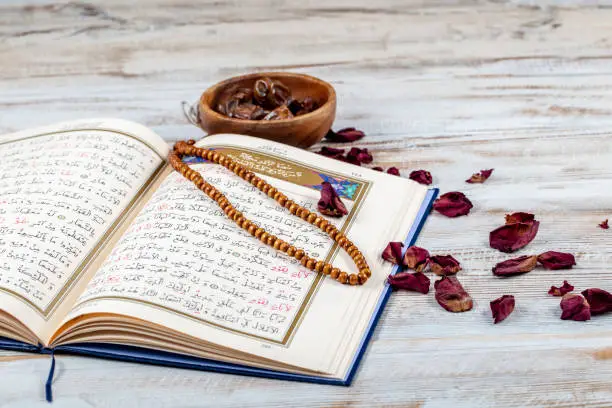 Koran - holy book of Muslims with rosary , date and dried flowers. ramadan concept