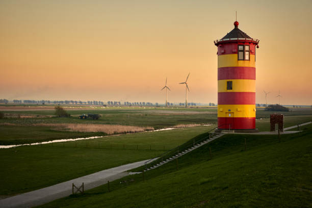 istock Red and yellow lighthouse at sunset in Pilsum / Lower Saxony 1145050178