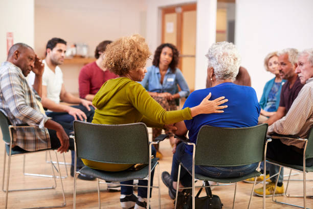 People Attending Self Help Therapy Group Meeting In Community Center People Attending Self Help Therapy Group Meeting In Community Center mental health photos stock pictures, royalty-free photos & images