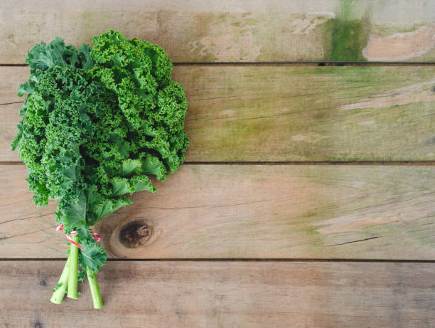istock Bunch of kale on wooden background. 1145054572