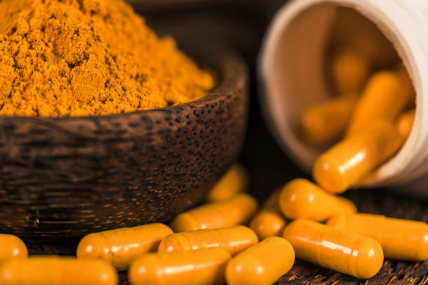istock Curcumin Herbal Supplement Capsules and Turmeric Powder 1145055425