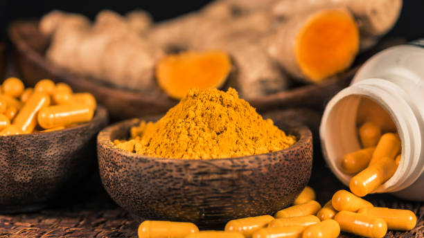 istock Curcumin Herbal Supplement Capsules and Turmeric Powder 1145055737