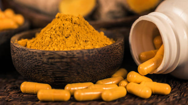 istock Curcumin Herbal Supplement Capsules and Turmeric Powder 1145055978