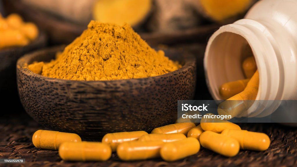 Curcumin Herbal Supplement Capsules and Turmeric Powder Curcumin herbal supplement capsules and turmeric powder in glass bowl. Anti-inflammatory herbal medicine (Curcuma) Curcumin Stock Photo