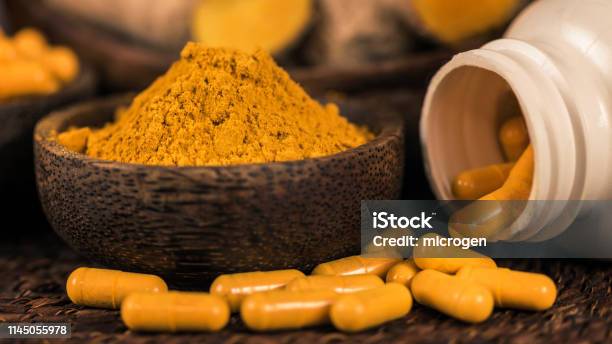 Curcumin Herbal Supplement Capsules And Turmeric Powder Stock Photo - Download Image Now