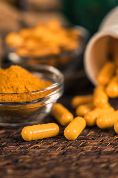 istock Curcumin Herbal Supplement Capsules and Turmeric Powder 1145056262