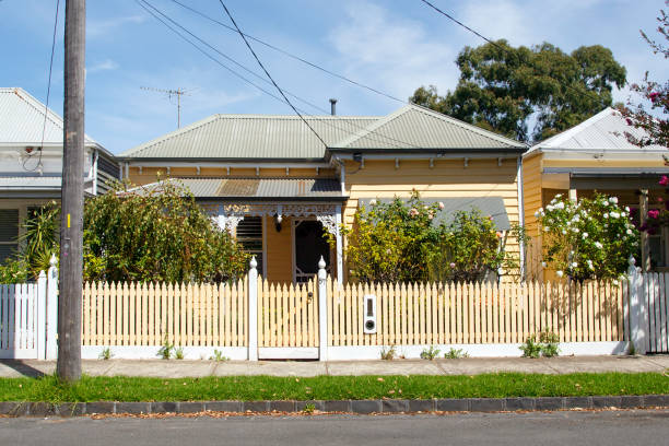 Traditional Bungalow with a painted picket fence - Melbourne Williamstown, Australia: March 07, 2019: Traditionally built bungalow in the 20th century Australian style in Williamstown with a porch, ornate verandah, garden gate and painted picket fence. traditionally australian stock pictures, royalty-free photos & images
