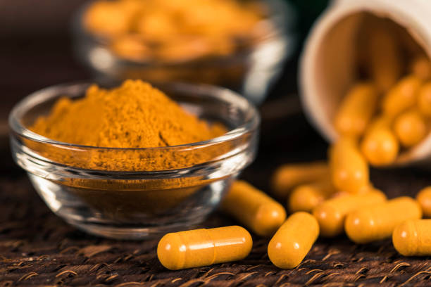 istock Curcumin Herbal Supplement Capsules and Turmeric Powder 1145057333
