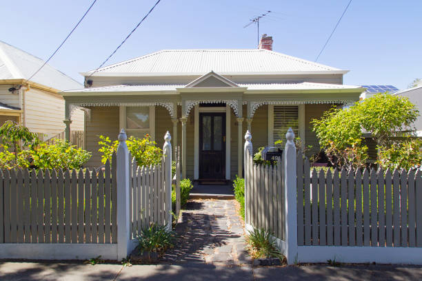 Traditional House with a painted picket fence - Melbourne Williamstown, Australia: March 07, 2019: Traditionally built bungalow in the 20th century Australian style in Williamstown with a porch, ornate verandah, garden gate and painted picket fence. traditionally australian stock pictures, royalty-free photos & images