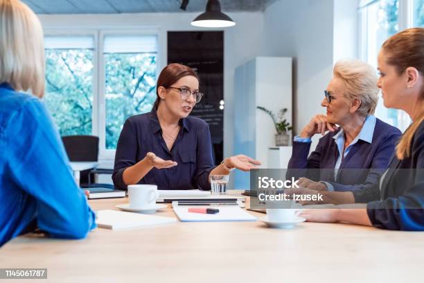 Executive Discussing With Colleagues In Meeting Stock Photo - Download Image Now - 35-39 Years, 40-44 Years, 70-79 Years