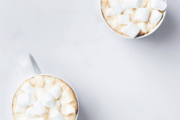istock Romantic desk top with two cups of coffee with marshmallows on marble table. Top view. 1145063275