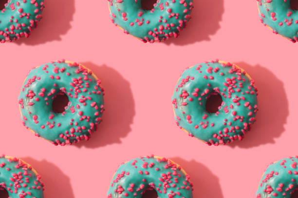 istock Minimal seamless pattern of donuts on coral background 1145063878