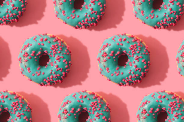 istock Minimal pattern of donuts on coral background 1145063880