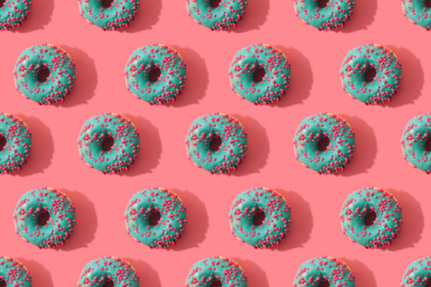 istock Minimal seamless pattern of donuts on coral background 1145063881