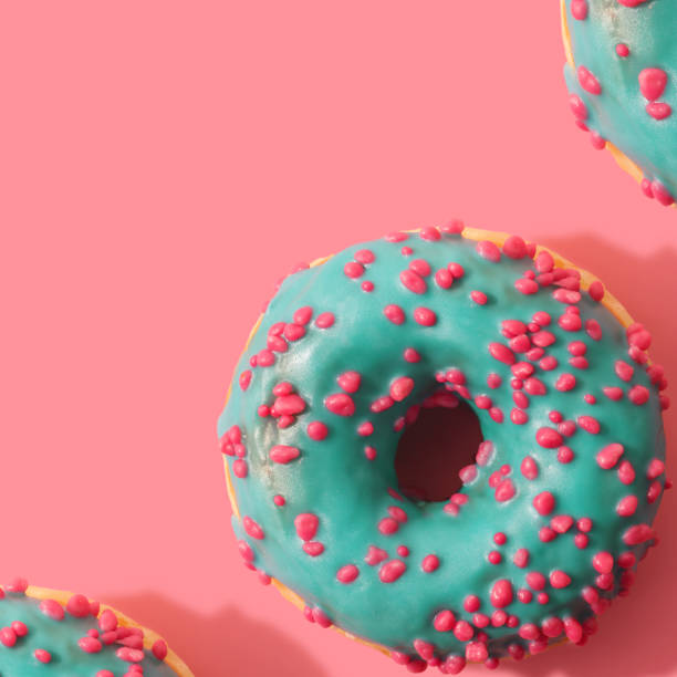 istock Minimal pattern of donuts on coral background 1145063893