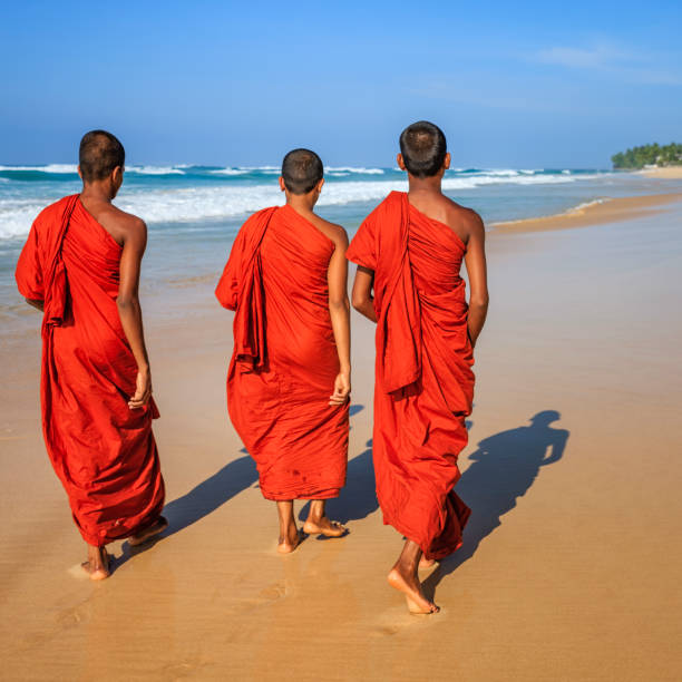 istock Sri Lankan young buddhist monks walking on the beach, Ceylon 1145064755