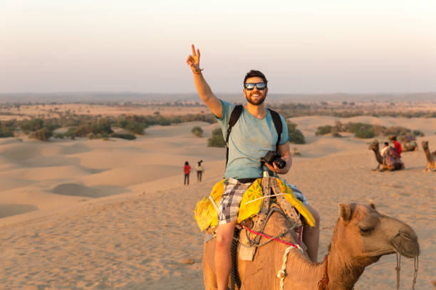 Tourist riding camel in Desert Tourist riding camel in Desert india tourism stock pictures, royalty-free photos & images