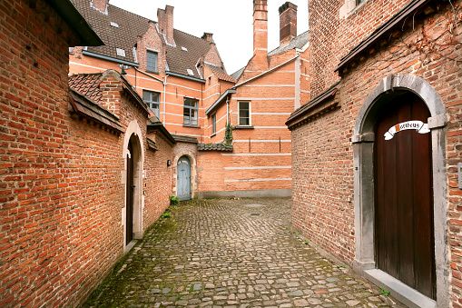 Antwerp, Belgium: Old narrow street at historical Beguinage, 13th century complex houses for beguines women on April 2, 2018. UNESCO as World Heritage from 1998