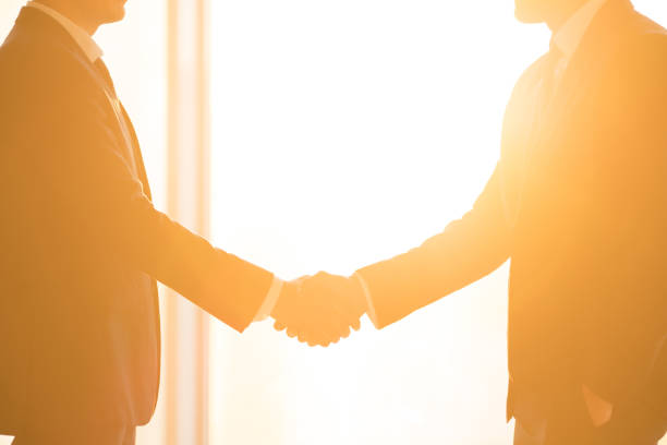 istock The businessmen handshake on the bright sun background 1145066124