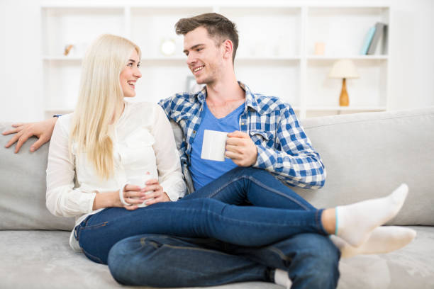 istock The happy couple with a cup relax on the sofa 1145066615