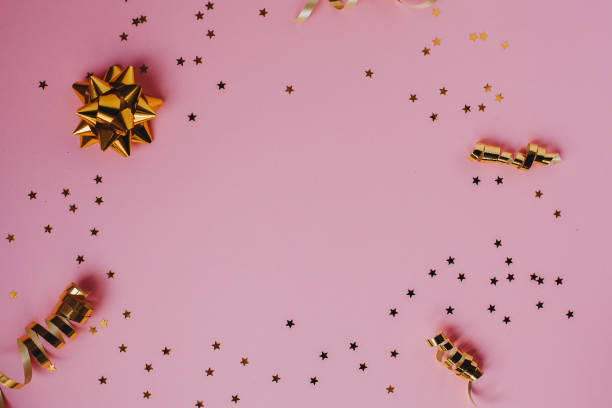 istock Golden decorations and sparkles on pink background 1145066729