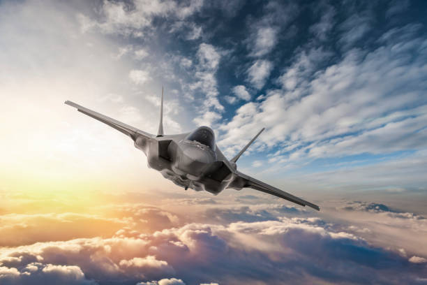 Fighter Jet flying over the clouds at sunset Fighter Jet flying over the clouds at sunset fighter plane stock pictures, royalty-free photos & images