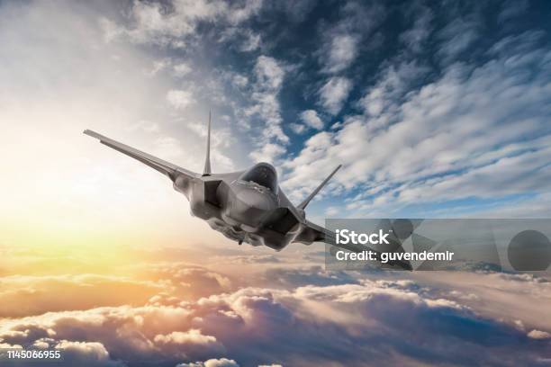 Fighter Jet Flying Over The Clouds At Sunset Stock Photo - Download Image Now - Fighter Plane, Air Force, War