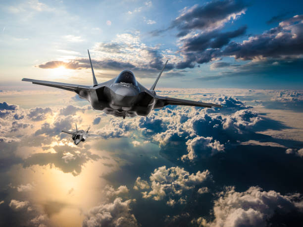 f-35 aviones de combate volando sobre las nubes al atardecer - jet fotografías e imágenes de stock
