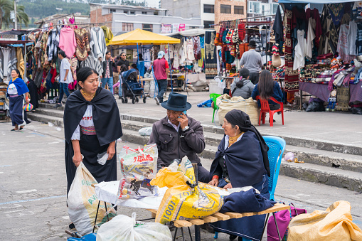 Otavalo, Ecuador - February 23, 2019: Busy traditional produce market, people in traditional clothing can be seen preparing and selling their goods and home made products.