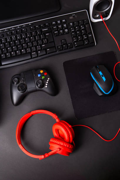 istock Top view a gaming gear, mouse, keyboard, joystick, headset, VR Headset on black table background. 1145069890