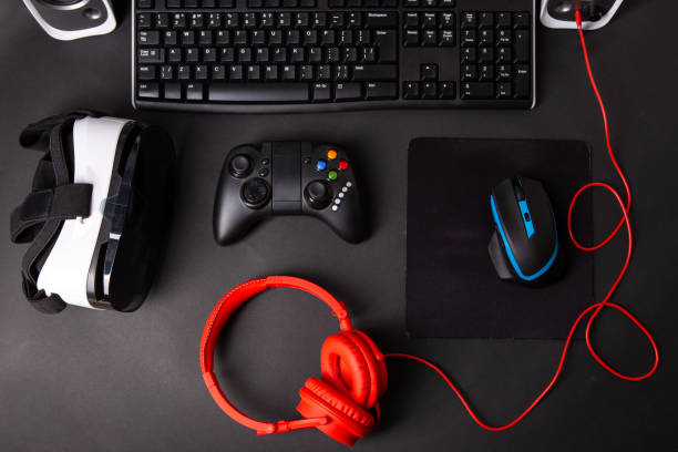 istock Top view a gaming gear, mouse, keyboard, joystick, headset, VR Headset on black table background. 1145069916