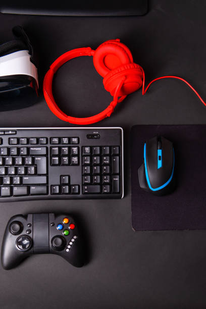 istock Top view a gaming gear, mouse, keyboard, joystick, headset, VR Headset on black table background. 1145069929