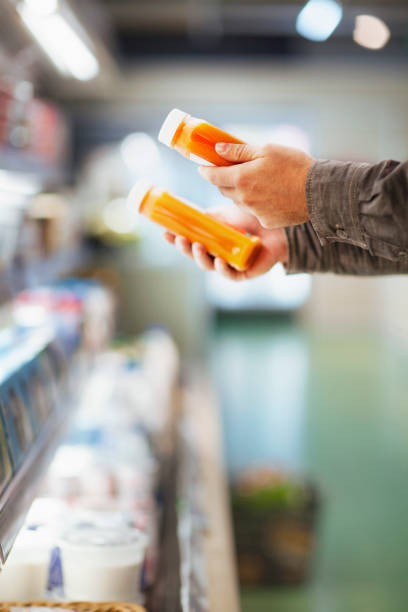 Hands holding juice bottles in supermarket