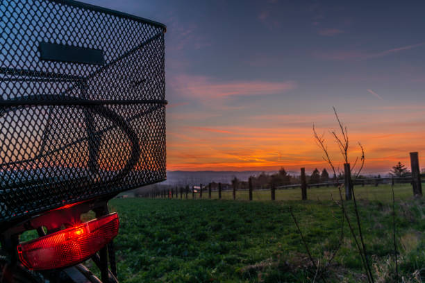 Black electric bicycle with sunset on light green meadow in spring color evening