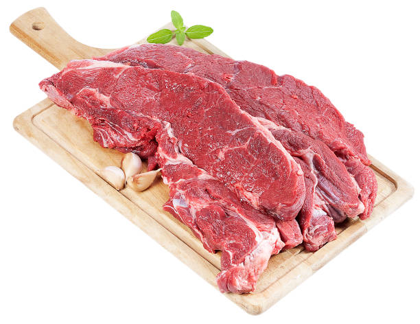 istock Raw beef on wooden plank with spices on white background 1145080245