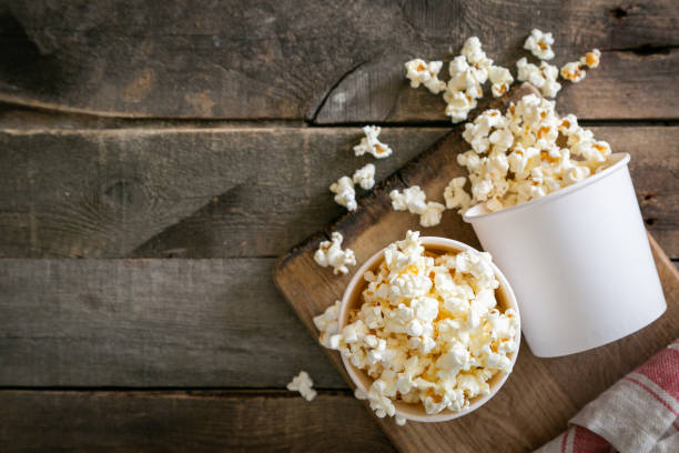домашняя поп-кукуруза в белых чашках на деревянном фоне - popcorn snack bowl corn стоковые фото и изображения