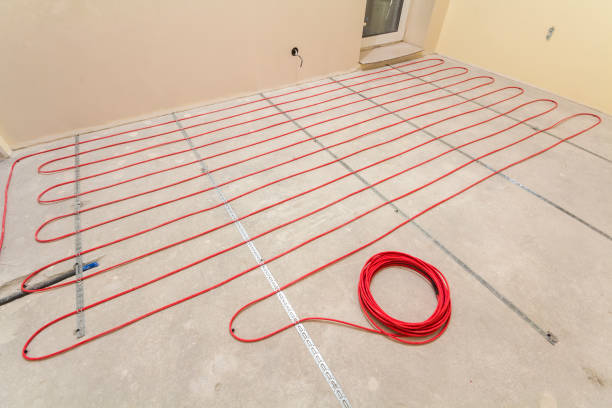 Heating red electrical cable wire roll on cement floor copy space background. Renovation and construction, comfortable warm home concept.