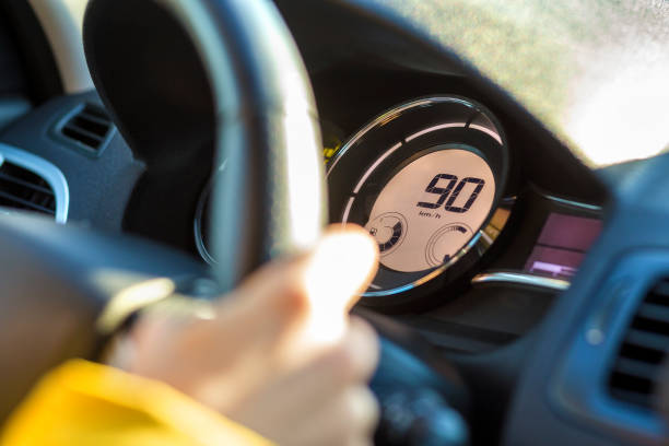 istock Modern car interior with driver hand on steering wheel and ninety km on speedometer. Safe driving concept. 1145081461
