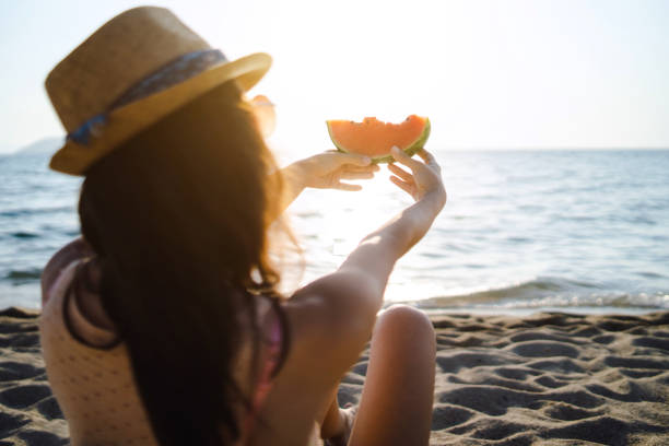istock Young woman with a watermelon on the beach 1145081821