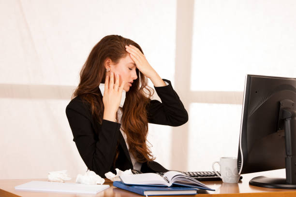 istock il woman suffering at work behind the desk in her office 1145083067