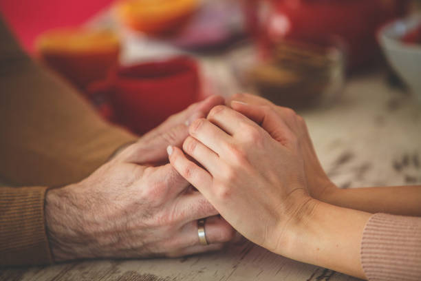 istock Married couple holding hands across the table 1145083601