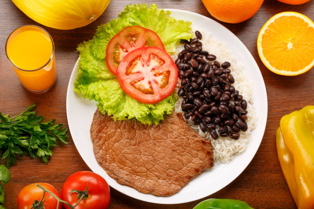 Bean, rice and steak with salad on wooden background stock photo