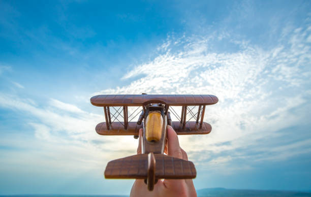 istock The hand launch a wooden plane on the blue sky background 1145086956