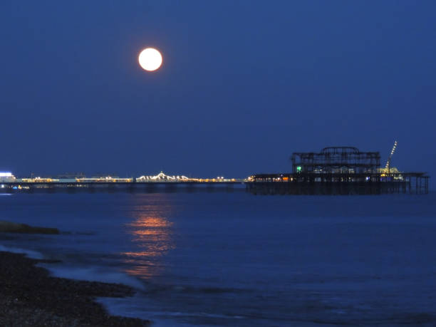 luna llena de rosa sobre brighton beach - palace pier tourism built structure sign fotografías e imágenes de stock