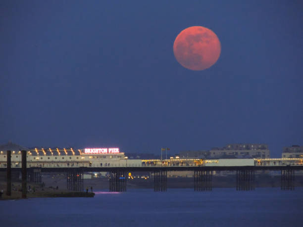 la luna llena rosa de abril sobre el muelle del palacio, brighton - palace pier tourism built structure sign fotografías e imágenes de stock