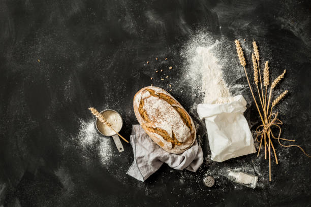 istock Bread, flour bag, wheat and measuring cup on black 1145088390